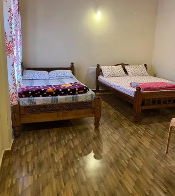 two twin beds in a room with wooden floors at cocostay coorg in Madikeri