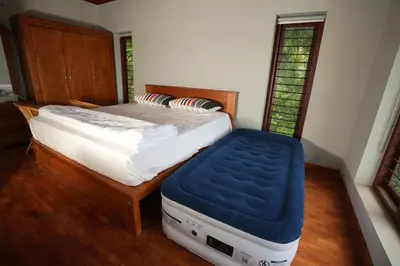 a bedroom with a bed with a blue mattress at Bellevue Homestay and Wellness Centre in Kozhikode