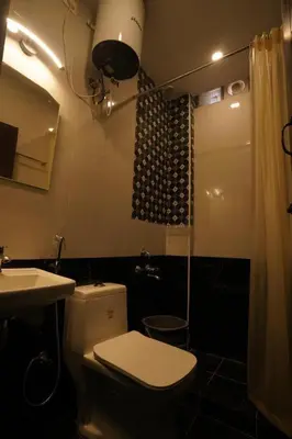 a bathroom with a toilet and a sink and a shower at Casa de Selas in Coonoor