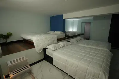 a bedroom with two beds and a mirror at Casa de Selas in Coonoor