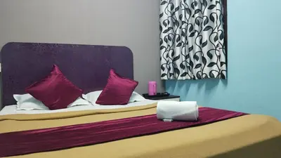 a bed with purple pillows and a laptop on it at Misty Stay by Le Apex in Ooty