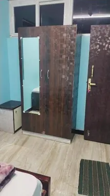 a room with a wooden door and a mirror at Misty Stay by Le Apex in Ooty