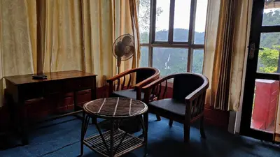 two chairs and a table in a room with a window at Valley View Avenue in Meppādi