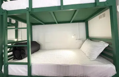 a bedroom with a bunk bed with a white mattress at ABODE Backpacker's Hostel in Madikeri