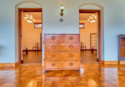 a wooden dresser in the middle of a room at Vintage Inglenook Premium Heritage Bungalow Ooty by VOYE HOMES - A Quiet Retreat Close to Ooty Town in Ooty
