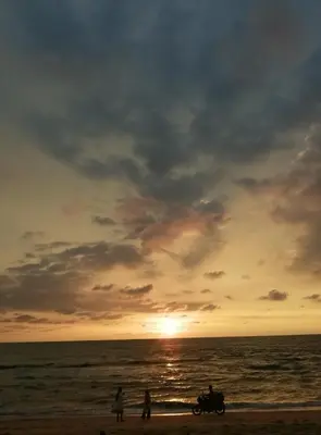 a group of people on the beach at sunset at Ocean Whisper- psst! hidden gem in Kaipamangalam