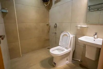 a bathroom with a toilet and a sink at Metro Residency in Tirūr