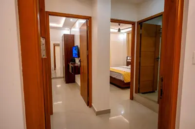 a hallway to a bedroom with a bed and a mirror at Metro Residency in Tirūr