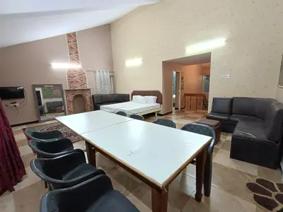 a living room with a white table and chairs at Mountain View Private Villa in Ooty