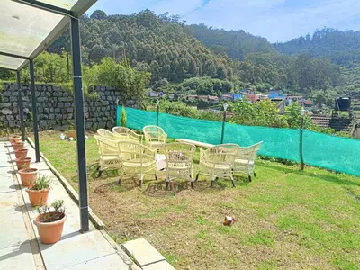 a group of chairs and a table with a view at Mountain View Private Villa in Ooty