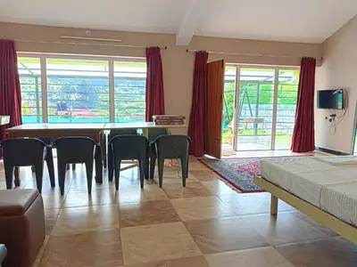 a room with a dining room table and chairs at Mountain View Private Villa in Ooty
