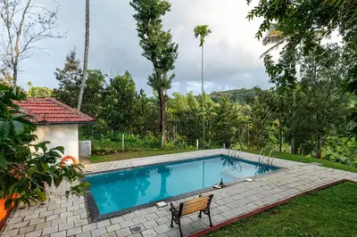 a swimming pool in the yard of a house at Mahogany by Exuberance Stays in Wayanad