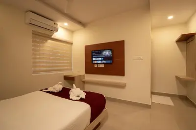 a bedroom with two cats sitting on a bed at BR Residency in Trichūr