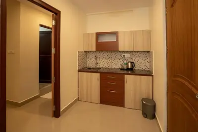 a kitchen with wooden cabinets and a counter top at BR Residency in Trichūr