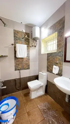 a bathroom with a toilet and a sink at Thapovan coimbatore in Coimbatore