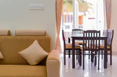 a living room with a couch and a table and chairs at Thapovan coimbatore in Coimbatore