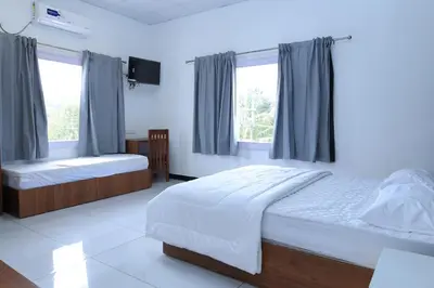 a bedroom with two beds and two windows at Iyer Square in Attappādi