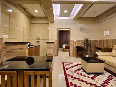 a living room with a couch and a table at Alicos Residency in Sultan Bathery