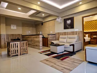 a living room with a couch and a table at Alicos Residency in Sultan Bathery