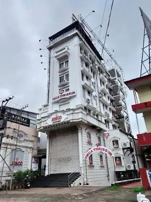 a tall white building with a sign on it at YMCA International Guest House in Trichūr