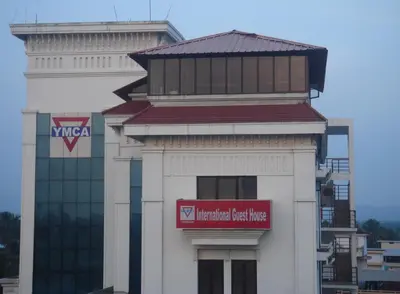 a building with a red sign on the side of it at YMCA International Guest House in Trichūr