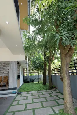 two trees in a yard next to a building at Ganga Homes Rooms Only in Trichūr