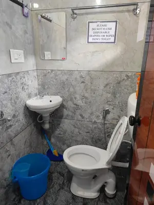 a bathroom with a toilet and a sink at Ganga Homes Rooms Only in Trichūr