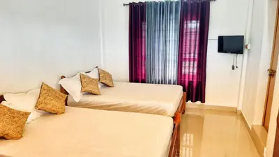 two beds in a room with a window at Brighton Retreat in Sultan Bathery