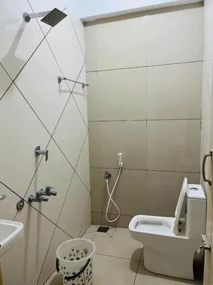 a bathroom with a shower and a toilet and a sink at Woodland residency in Mettuppālaiyam