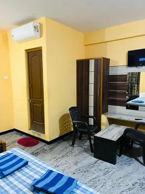 a room with a desk and a table and chairs at Woodland residency in Mettuppālaiyam