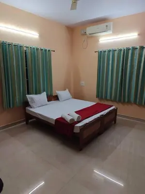 a bedroom with a large bed with green curtains at S R Luxurious Fully Ac 3 BHK Bunglow Mysore in Mysore