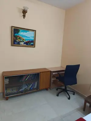 a desk with a television and a chair in a room at S R Luxurious Fully Ac 3 BHK Bunglow Mysore in Mysore