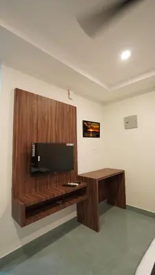 a living room with a flat screen tv on a wooden wall at Hotel Hive Inn - Kozhikode in Kozhikode