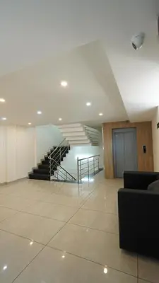 a lobby with a staircase in a building at Hotel Hive Inn - Kozhikode in Kozhikode