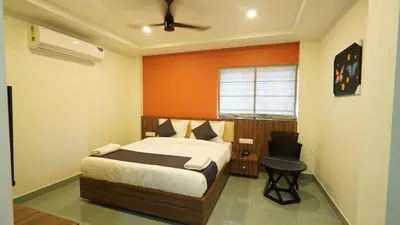 a bedroom with a bed and a chair in it at Hotel Hive Inn - Kozhikode in Kozhikode