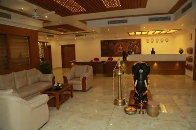 a lobby with couches and a bar in the background at Hotel Savera Park in Trichūr