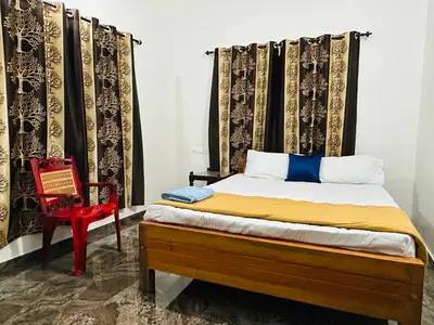 a bedroom with a bed and a red chair at Montage Villa in Kozhikode
