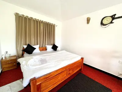 a bedroom with a large bed with a clock on the wall at Earth songs by Green leaves - 10 kms from kotagiri in Kotagiri
