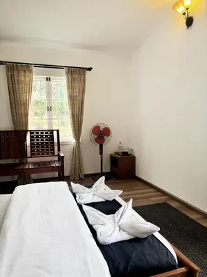 a bedroom with a bed with white sheets and a window at Earth songs by Green leaves - 10 kms from kotagiri in Kotagiri