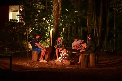 a group of people sitting around a fire at BLUE CREEK in Meppādi
