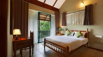 a bedroom with a bed and a large window at Silvertrails in Kalpetta