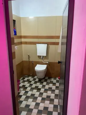 a bathroom with a toilet and a checkered floor at Dream inn family homestay in Meenangadi