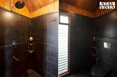 a black bathroom with a toilet and a window at StayVista at Reflection by The Woods - Breakfast Included - Luxury Villa in Madikeri