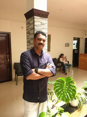 a man standing in a room with his arms crossed at Spectrum stays in Ambalavayal