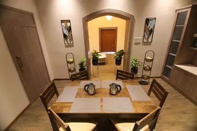 a dining room with a table and chairs at CATALEYA Home Stay in Kotagiri