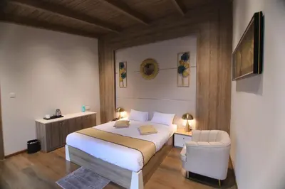 a bedroom with a bed and a chair in it at CATALEYA Home Stay in Kotagiri