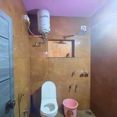 a small bathroom with a toilet and a light at Wayanad Empire Budget Villa in Kalpetta