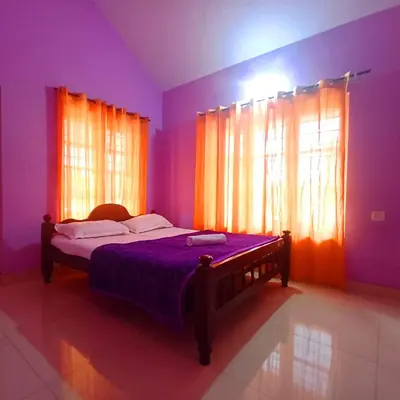 a bedroom with a bed with purple walls and windows at Wayanad Empire Budget Villa in Kalpetta
