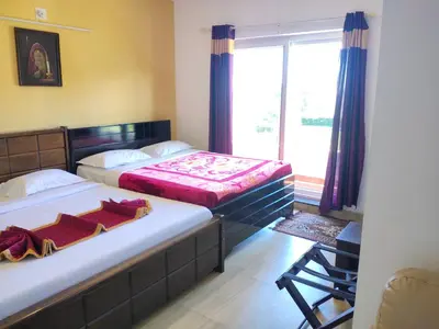 two beds in a room with a large window at Forest Gate villa in Ooty