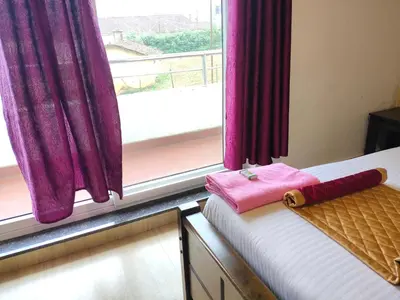 a bed in a room with a window with purple curtains at Forest Gate villa in Ooty